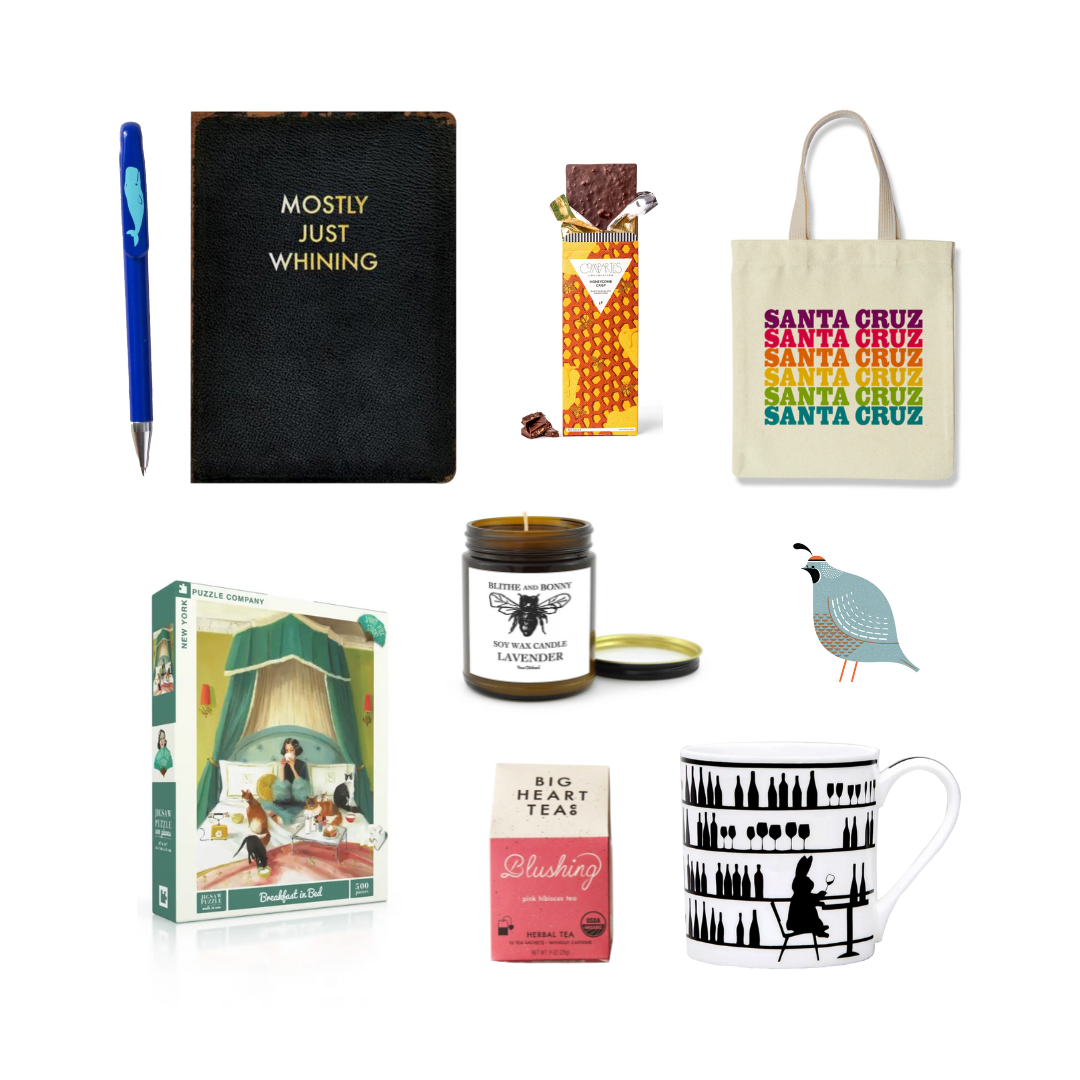 Gift collection containing a pen with a whale, a black journal with Mostly Just Wihining on it, a chocolate bar, a tote bag with santa cruz on it, a puzzle, a sented candle, a quail sticker, a box of tea and a black and white mug with a rabbit 