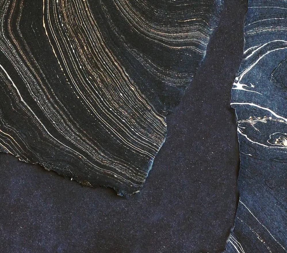 Artistic detail of hand-marbled paper featuring intricate gold and black swirls, perfect for The Casual Bookbinder's Softcover Notebook.