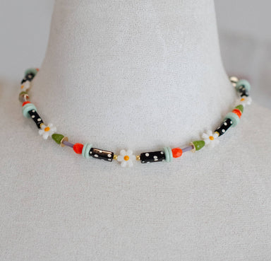 Handmade black and white polka dot flower necklace featuring vibrant beads and daisy accents, guaranteed to make you the most stylish bee at the party!