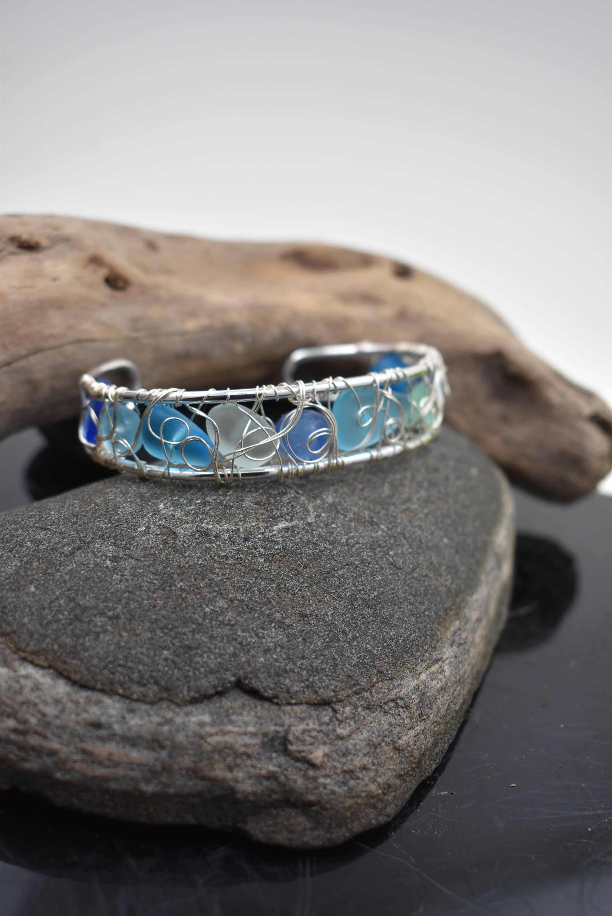 Modern wire woven eco glass cuff bracelet showcasing aqua and seafoam tones, handcrafted with recycled glass, perfect for ocean-inspired jewelry lovers.