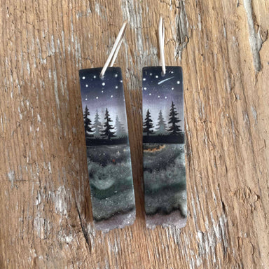 Crystal Forest Earrings by Fernworks featuring hand-painted pines under a starry night sky, encapsulated in polished resin with slices of amethyst and jasper, measuring approximately 1.5" x 0.5".