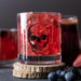 Skull cocktail glass with ice and red liquid