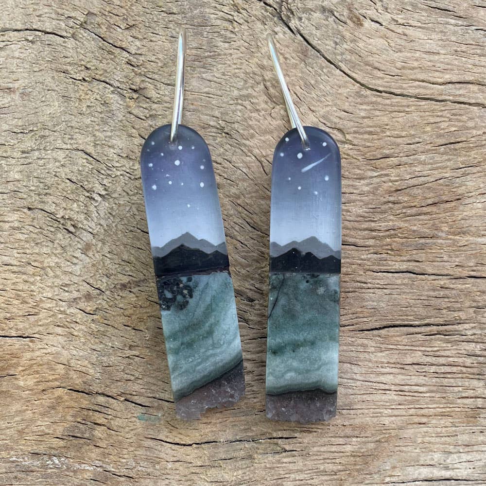 Fernworks Crystal Hills Earrings featuring hand-painted landscapes under a night sky, made with polished resin and adorned with amethyst and jasper accents. Each earring measures approximately 1.5" x 0.5".