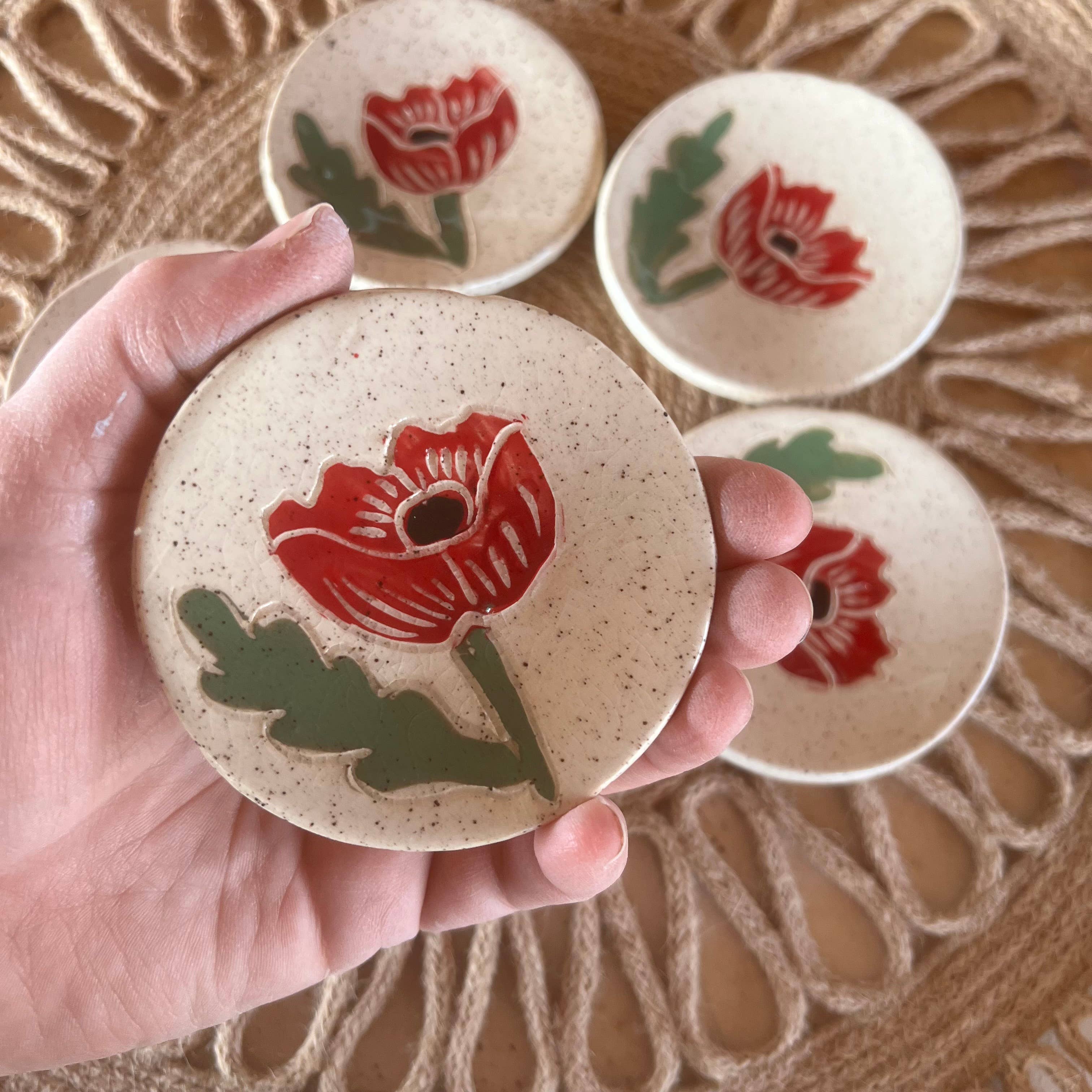 Individual Red Poppy Tea Rest mini dish held in a hand, showcasing the unique handcrafted detail by Tough Kitty Designs, ideal for spices and small items.
