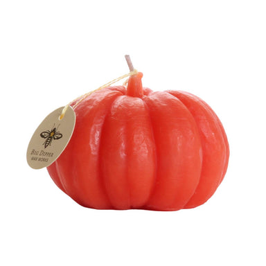 Pumpkin-shaped candle with a visible brand tag 