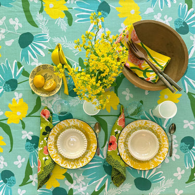 Elizabeth Grubaugh Tablecloths with a vibrant print of blue echinacea flowers, perfect for casual luncheons and seaside dinner parties.