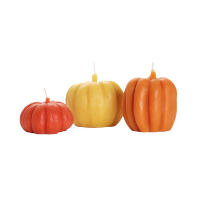 Three pumpkin-shaped candles in red, yellow, and orange 