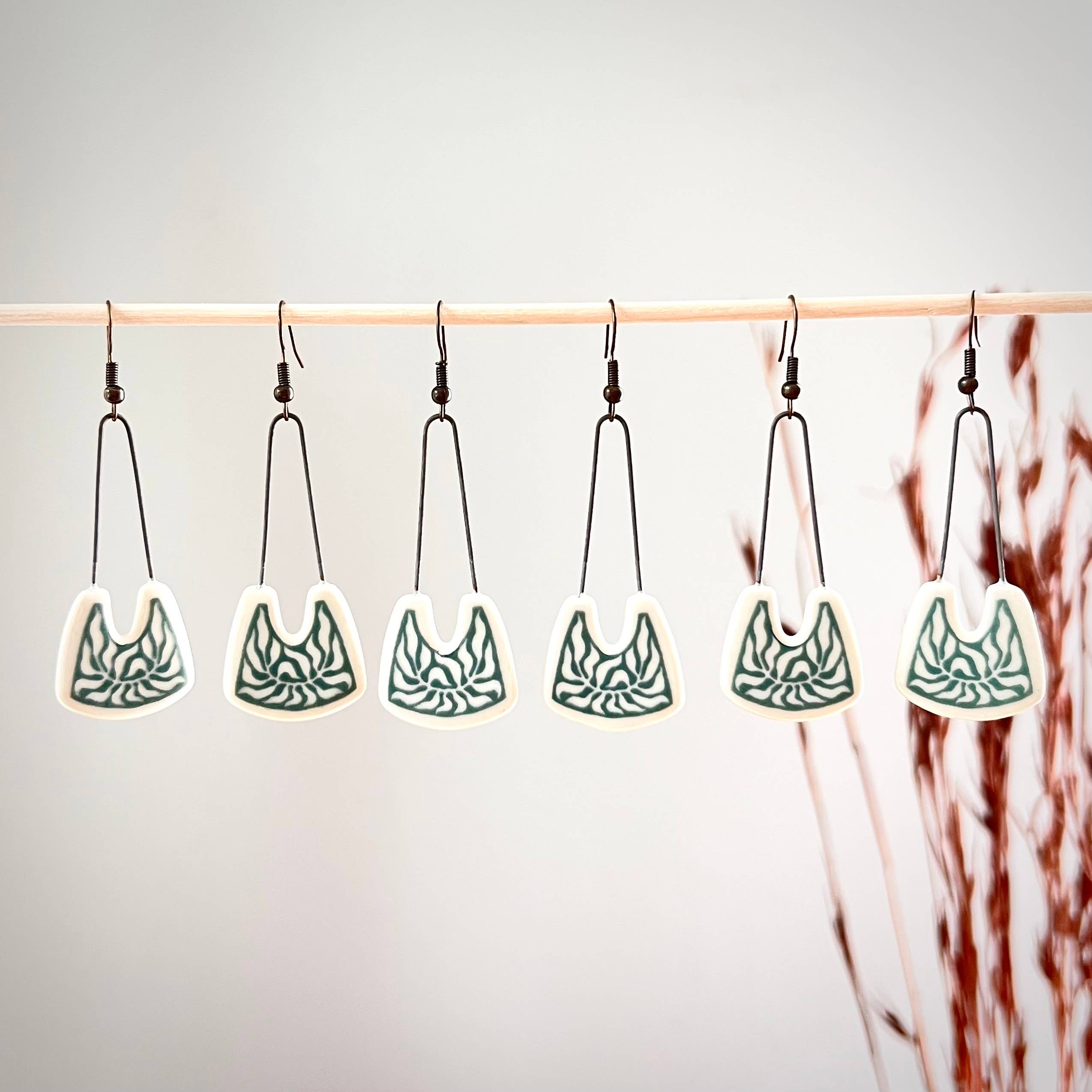 Multiple Teal Negative Space Leafy Earrings by The Artifact House displayed together, showcasing their playful satin finish and botanical artwork.