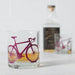 whiskey glass with purple bicycle print