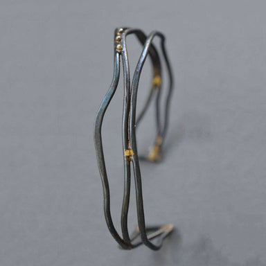 Narrow Organic Linear Cuff Bracelet showcasing modern elegance made from forged steel wire, complete with fancy brass braiding—perfect for your wrist and making your arm feel posh without breaking the bank!