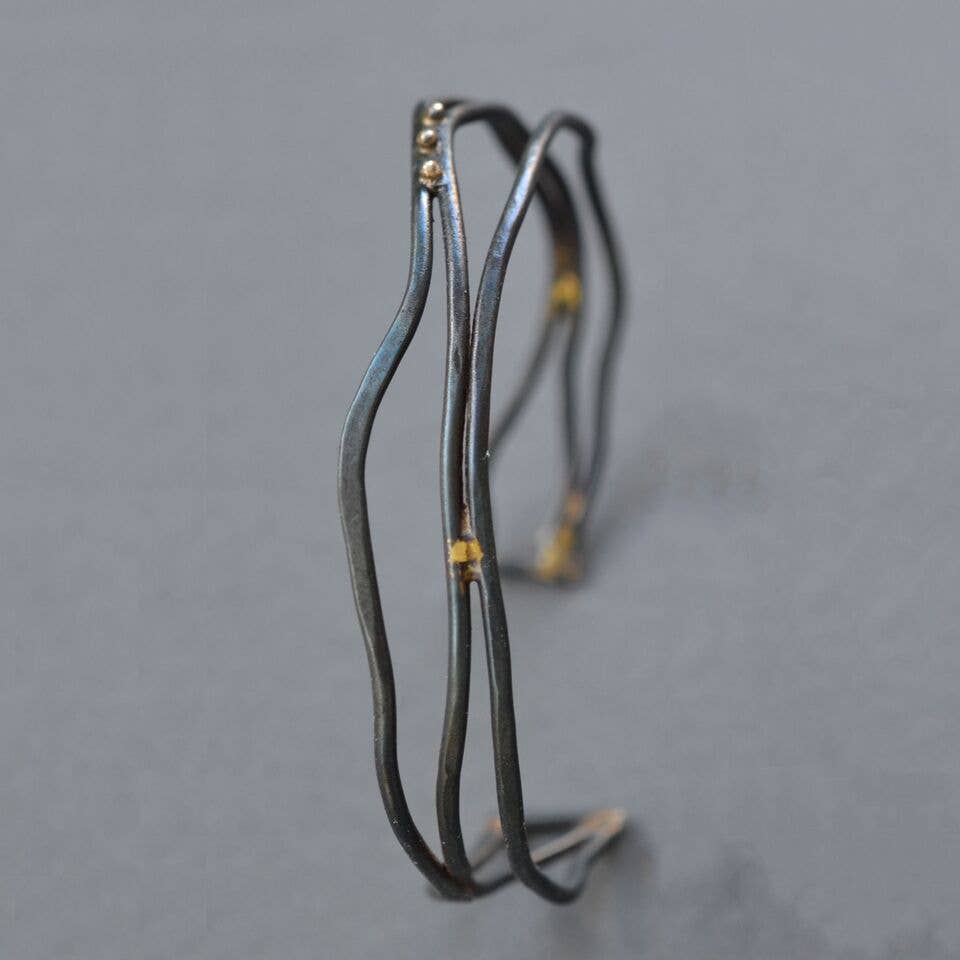 Narrow Organic Linear Cuff Bracelet showcasing modern elegance made from forged steel wire, complete with fancy brass braiding—perfect for your wrist and making your arm feel posh without breaking the bank!