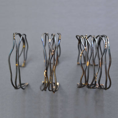 Close-up of the Narrow Organic Linear Cuff Bracelet, emphasizing the chic design with recycled 10K yellow gold accents—because your jewelry should be as eco-friendly as your coffee habit, right?
