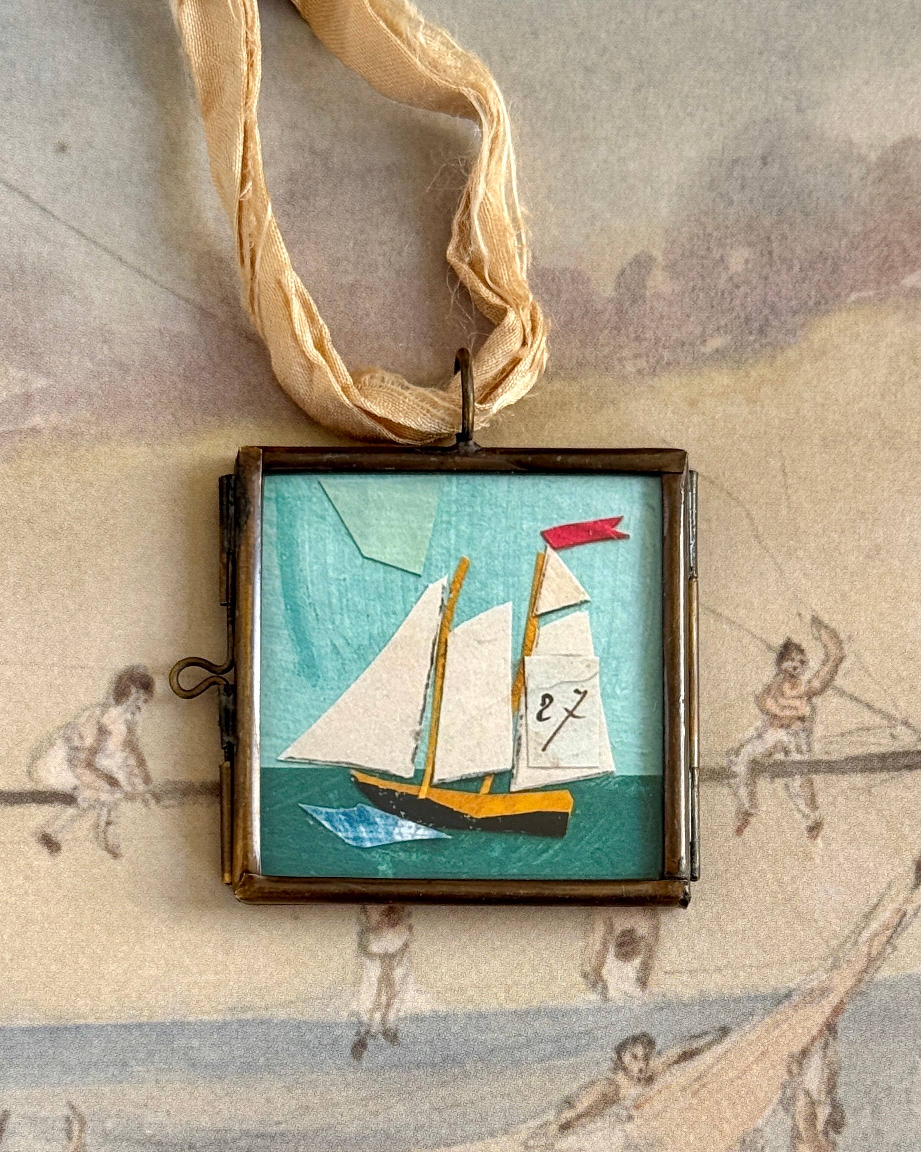Vintage-style sail boat art locket ornament.