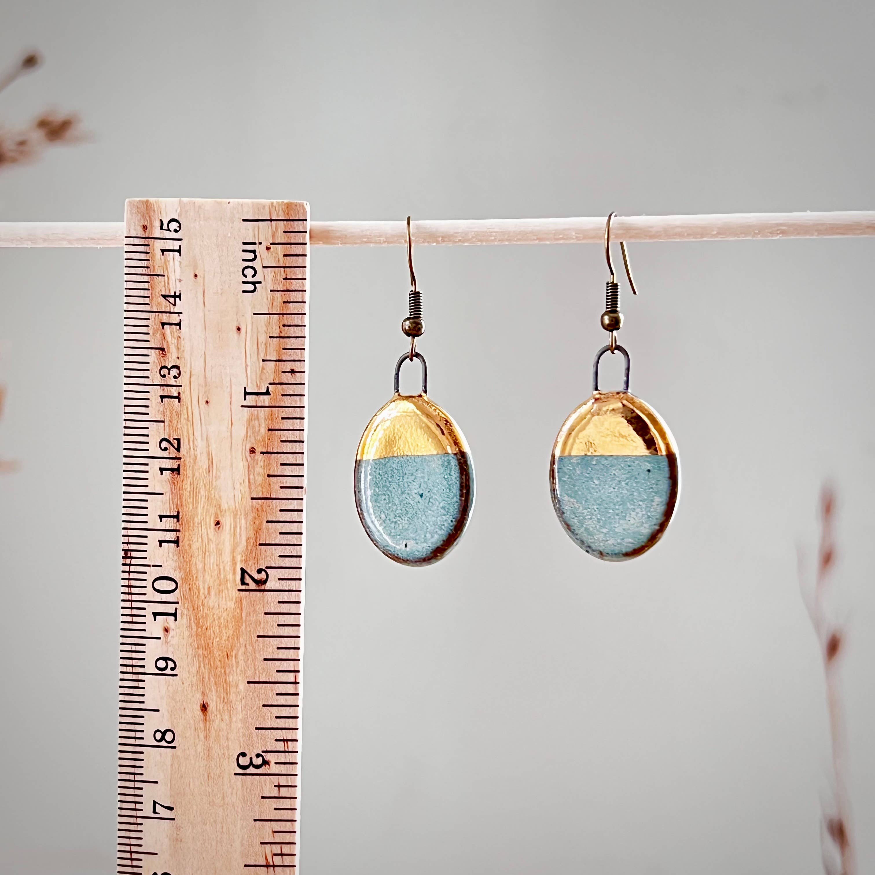 Turquoise Dipped Oval Gold Earrings from The Artifact House, shown next to a ruler for scale, highlighting their handcrafted charm and unique color combination.