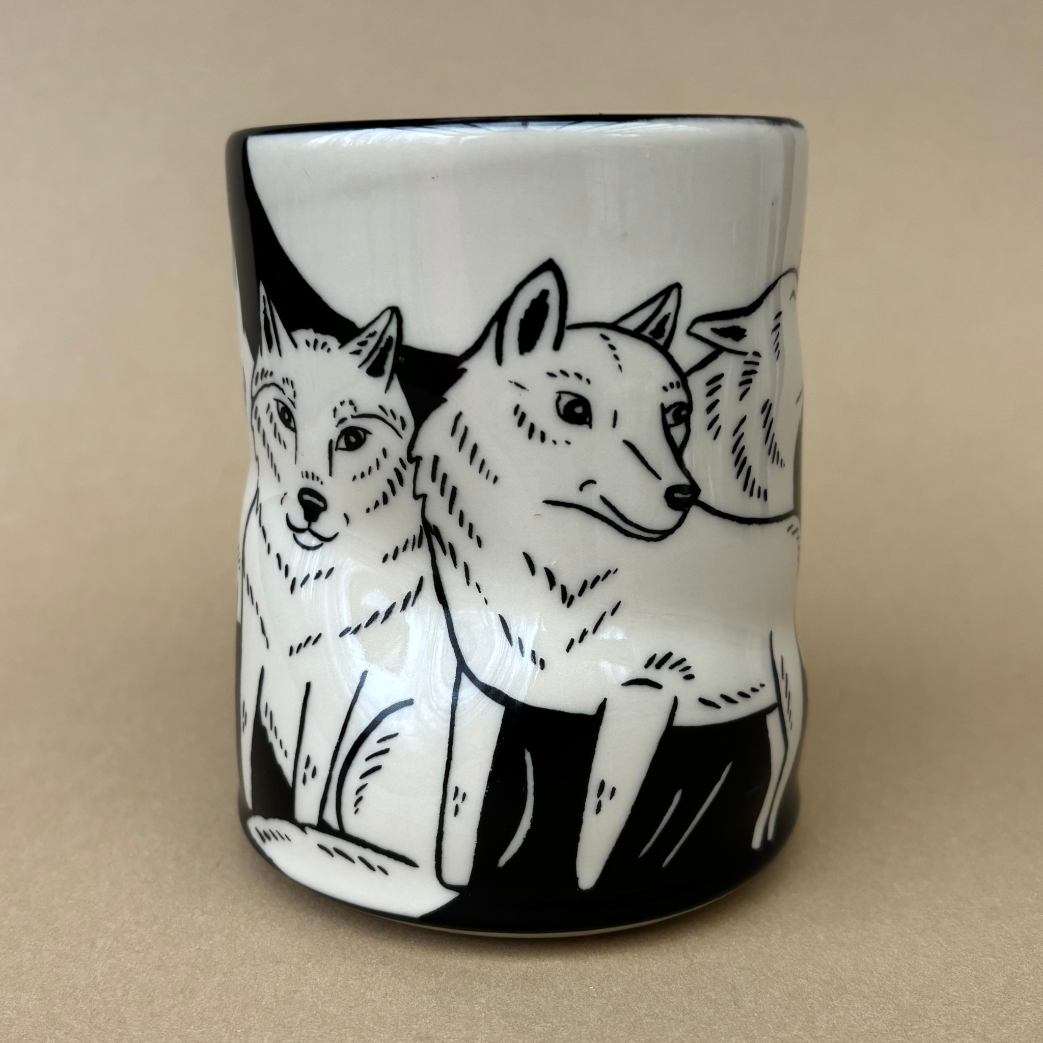 Lucky Wolf Cup - XLarge featuring intricate black and white illustrations of wolves. Designed by The Bowl Maker, this ceramic cup showcases artistic details on all sides.