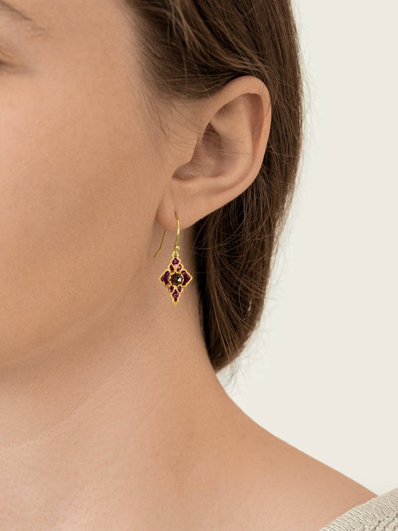 Close-up of the Esme Earrings with garnet gems wrapped in rose-swirled niobium. Because who doesn't want earrings that could double as shiny little vines?