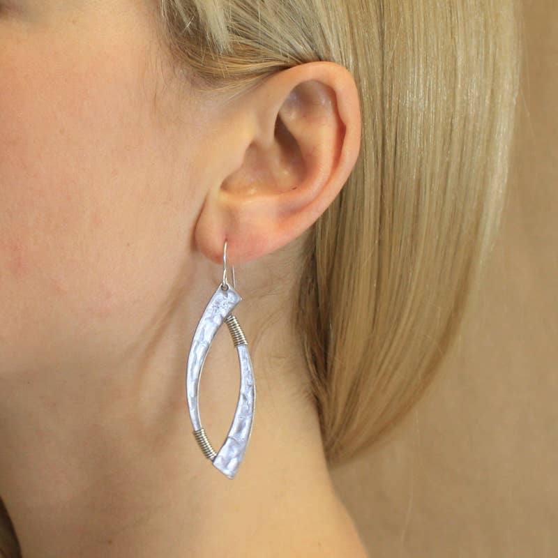A model wearing Wire-Wrapped Swoops Earring by Marjorie Baer, showcasing the elegant and artistic design of these statement earrings.