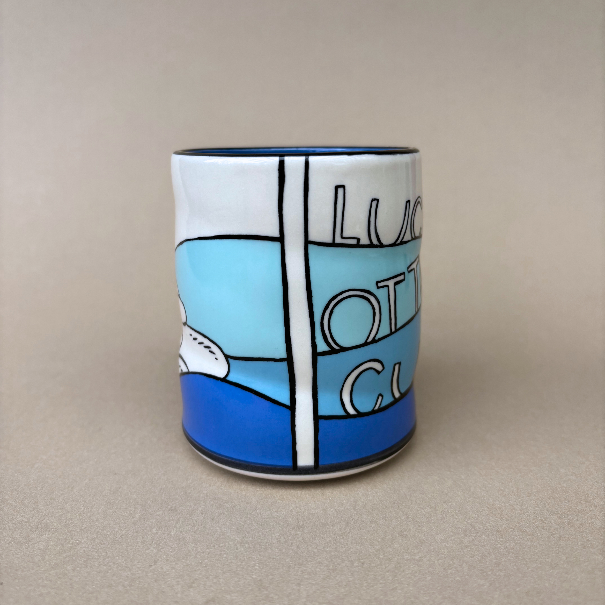 Lucky Otter Cup displaying a side view with artistic text and ocean hues, created by The Bowl Maker.