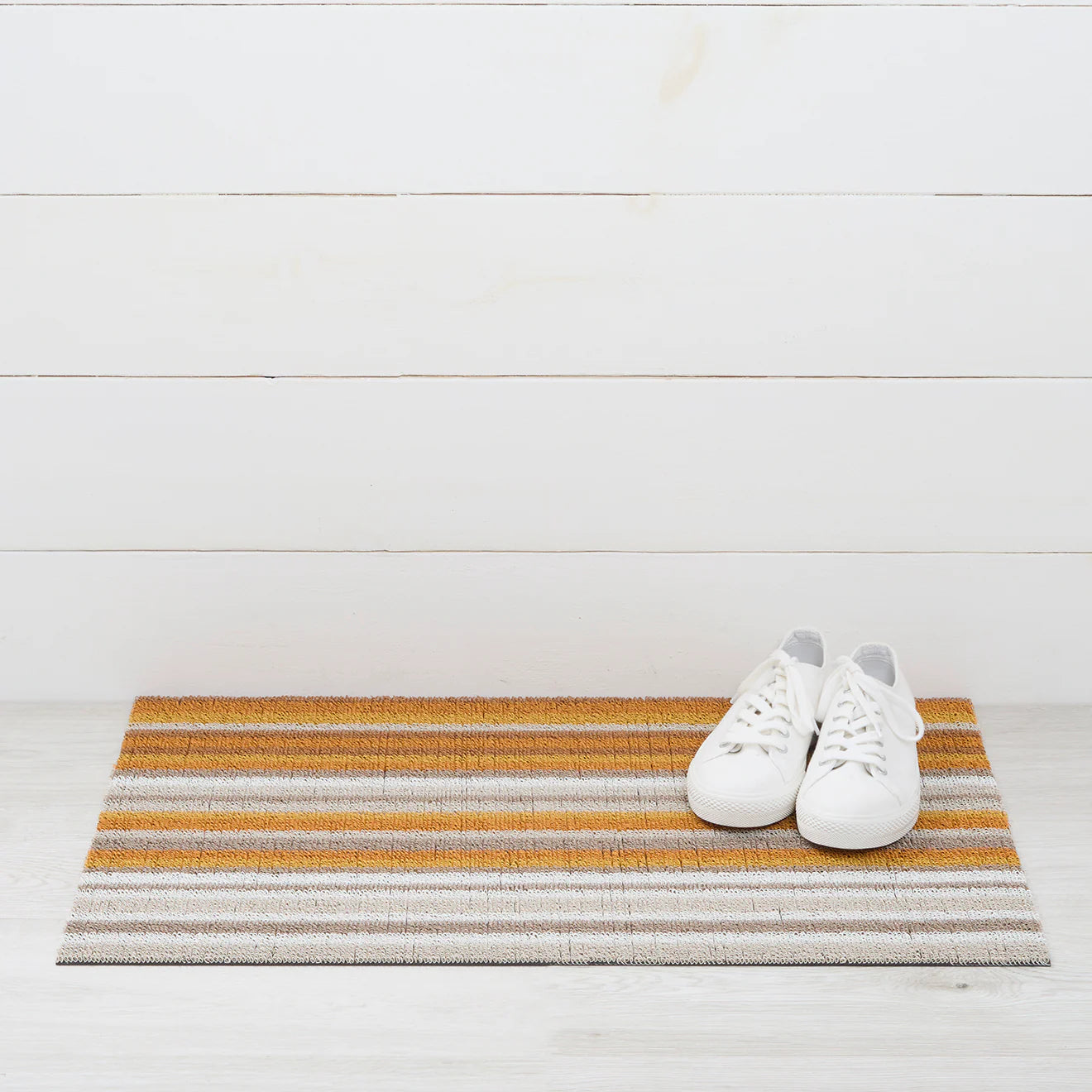 Close-up of Horizon Stripe Shag Mat in Desert by Chilewich, showcasing its textured looped TerraStrand yarns that are resistant to mold, mildew, and chlorine.