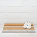 Close-up of Horizon Stripe Shag Mat in Desert by Chilewich, showcasing its textured looped TerraStrand yarns that are resistant to mold, mildew, and chlorine.