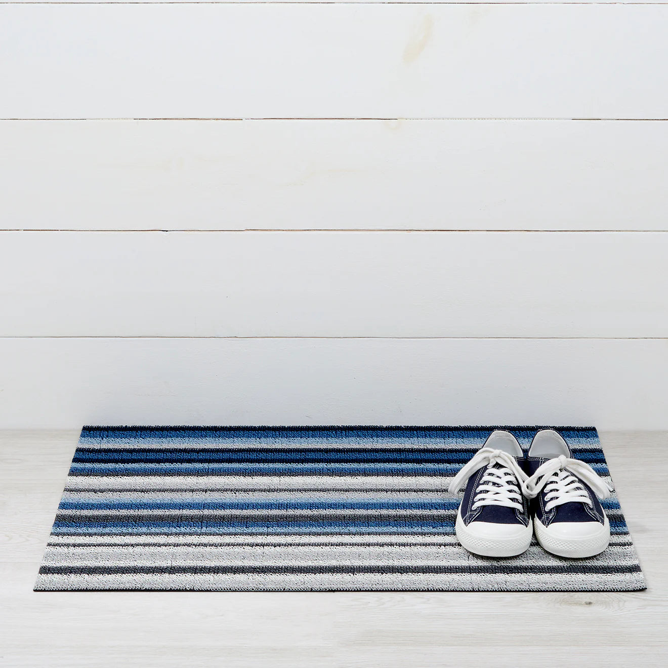 Horizon Stripe Shag Mat in Deep Sea by Chilewich, showcasing its vibrant waves of color and looped texture, perfect for entryways and patios.