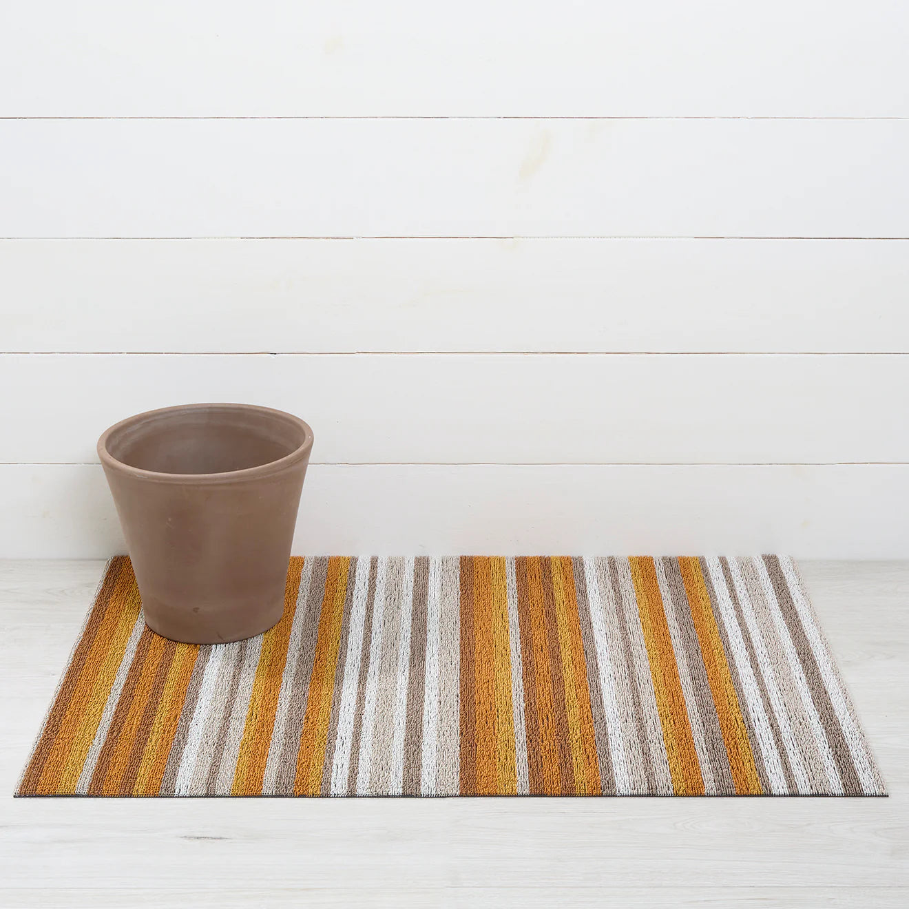 Horizon Stripe Shag Mat in Desert color displayed in a stylish entryway, ideal for high-traffic areas and enhancing home decor with its rhythmic striped design.