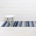 Horizon Stripe Shag Mat in Deep Sea displayed in a bathroom setting, emphasizing its stylish and functional design to keep spaces clean.