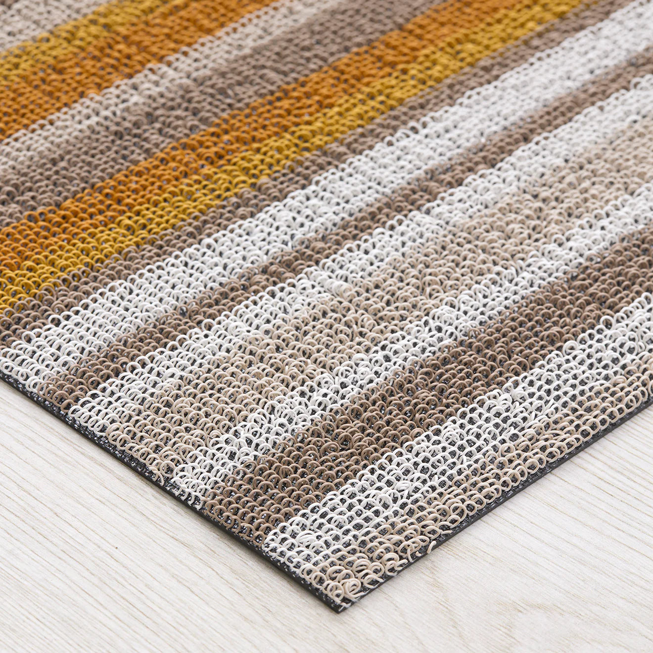 Horizon Stripe Shag Mat displayed in a stylish entryway, ideal for indoor and outdoor use.