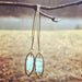 Icy Blue Brass Dangle by Suzanna Garrett Designs — icy blue glass gets a warm brass frame in these elegant drop earrings