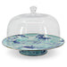Enamelware Lagoon Cake Plate by Crow Canyon Home featuring a marbled design in cobalt blue and sea glass colors, displayed under a glass dome.