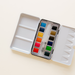 12 Color Mini-Travel Watercolor Paint Palette with a built-in mixing area for effortless color blending.
