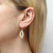 Close-up view of Small Overlap Swoops Wire Earring showcasing the intricate craftsmanship and unique two-tone metal color of brass and silver.