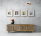 Living room interior with four framed bird art prints above a wooden console.