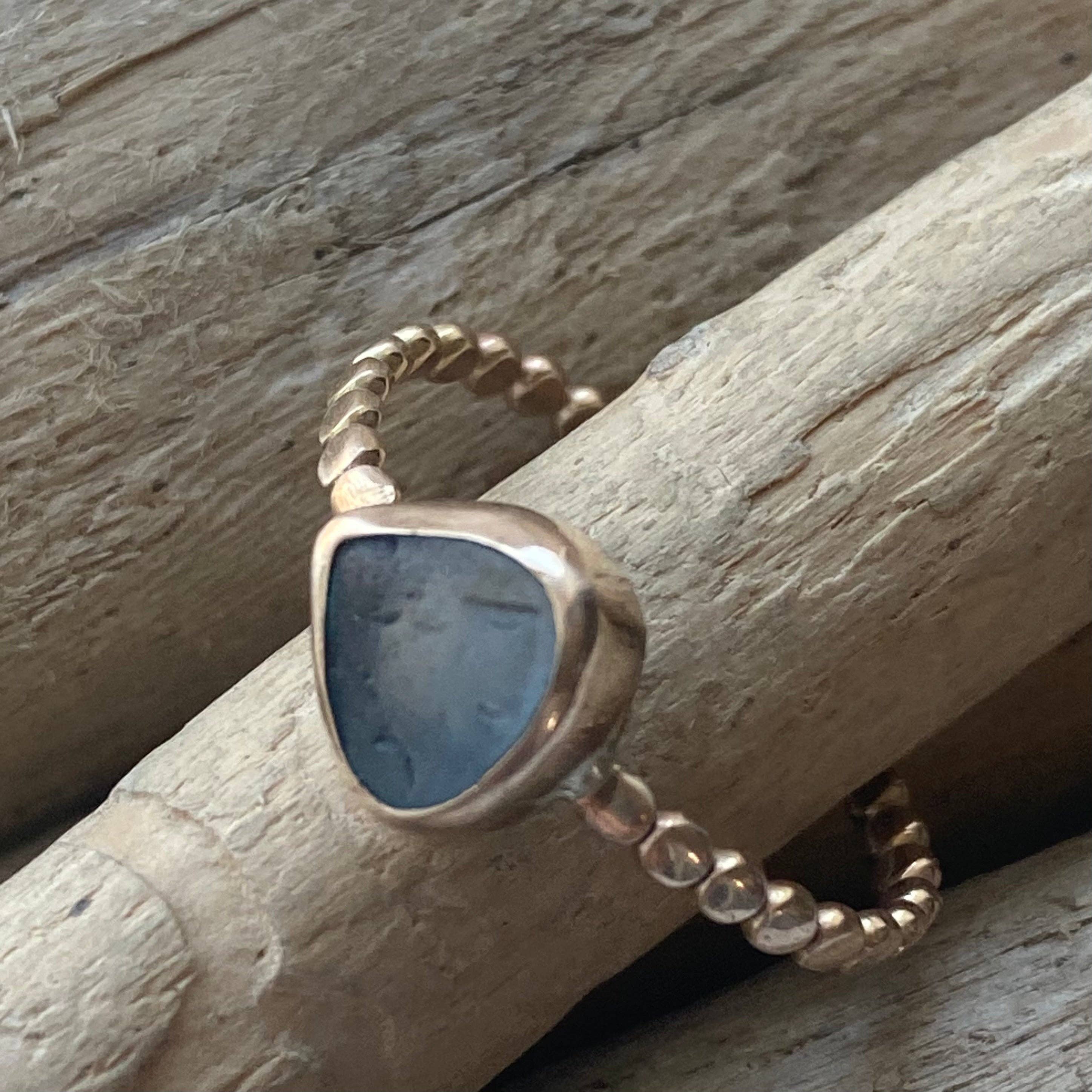 The Repetition Band by Kate Samson Design, illustrating a one-of-a-kind sea glass ring with a triangular shape, set in a hand-crafted 14k gold fill bezel and beaded band.