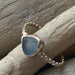 The Repetition Band by Kate Samson Design, illustrating a one-of-a-kind sea glass ring with a triangular shape, set in a hand-crafted 14k gold fill bezel and beaded band.