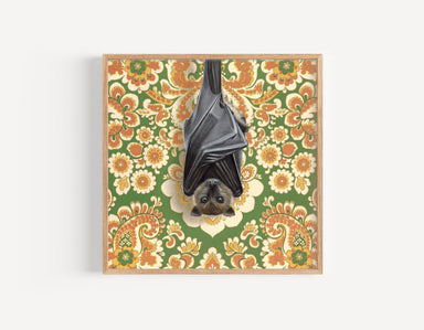 Framed art print of a bat hanging upside down against retro floral pattern background