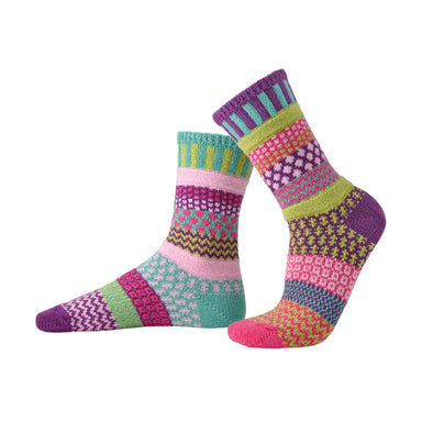Colorful Dahlia Crew Socks by Solmate Socks featuring a cheerful mix of light pink, magenta, lime green, purple, and turquoise patterns. Perfect for adding style and comfort to any outfit.