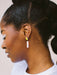 Close-up of Split Dip Earrings by Twenty Two West on a woman's ear, highlighting the unique design and bright colors that add a playful touch to her look.
