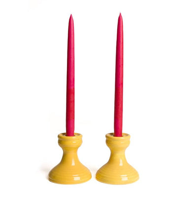 yellow candlestick holder with red candles