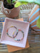 Colorful beaded Gold hoop earrings on a pink tray