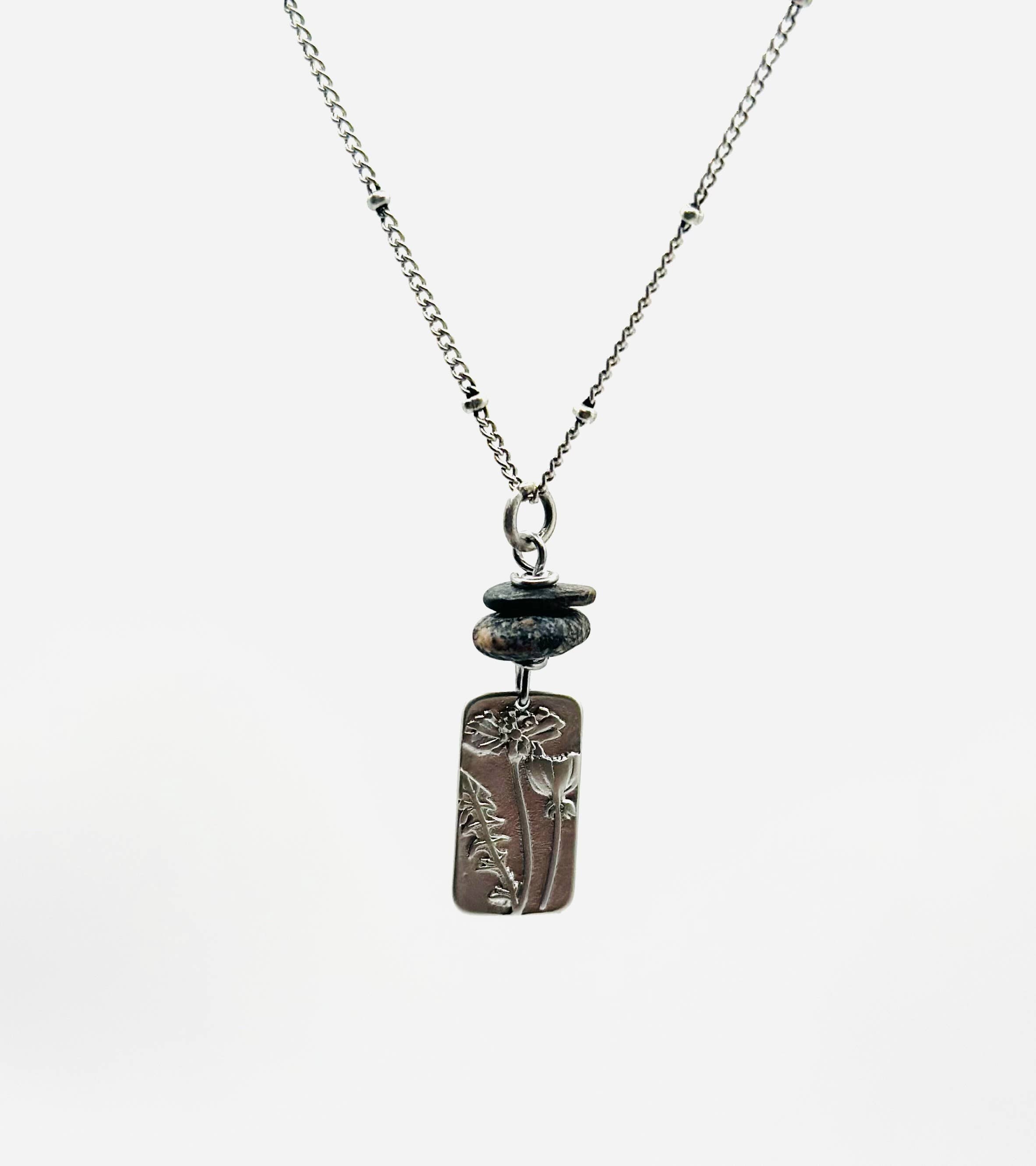 Flower Power Necklace by Suzanna Garrett Designs — a dainty wildflower pendant gets a little extra texture from dark river stone pebbles