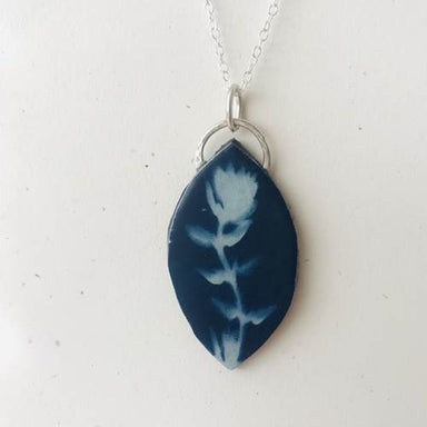 Broad Leaf Botanical Cyanotype Necklace by Joanna Lynn Taylor, featuring a handmade blue-and-white botanical pendant on an 18-inch hammered silver chain—nature’s tiny masterpiece, no watering required.