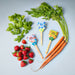 Flat lay of basil, carrots, strawberries, and Seed Pops from Modern Sprout including Sweet Basil and Carrot Bunch, all part of the Garden Seed Pop collection.