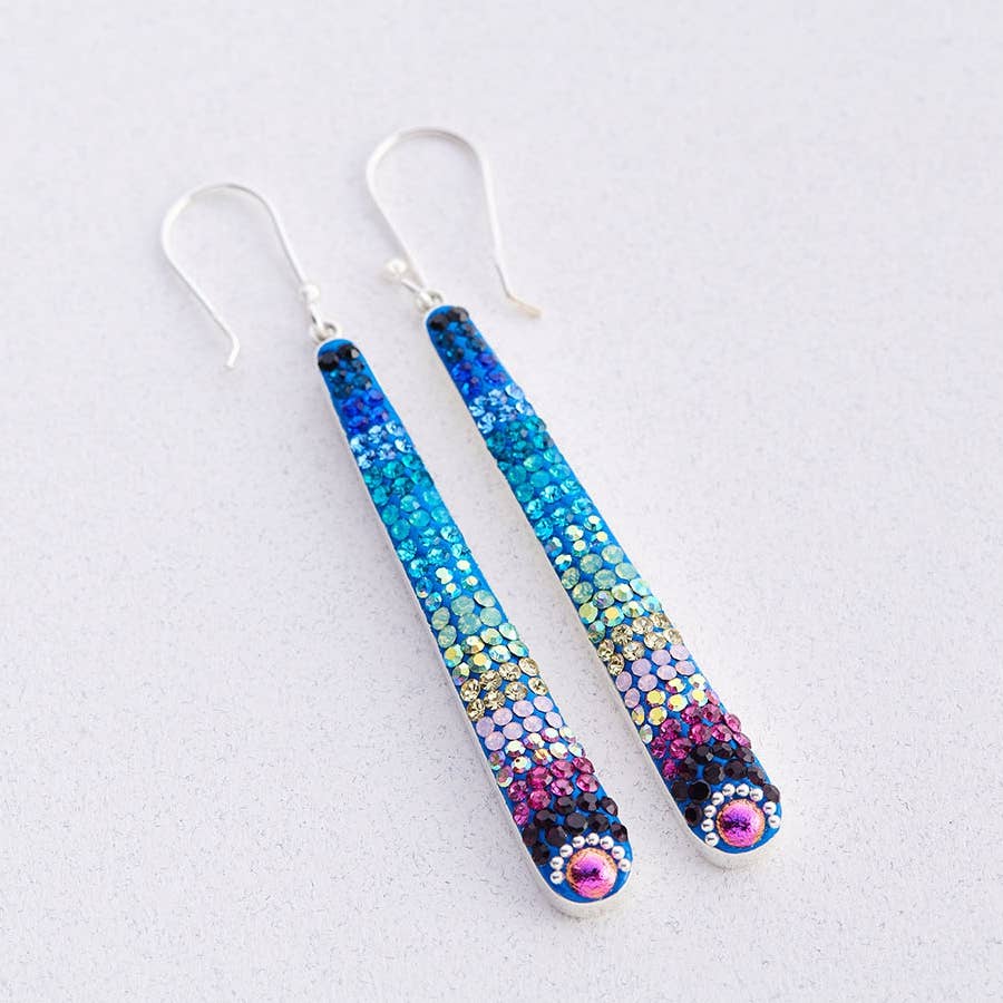 Stunning Crystal Dash Earrings by Mosaico Jewels featuring a sleek, elongated design adorned with vibrant blue and purple crystals, perfect for adding a modern touch to any outfit.