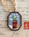 Vintage-style flower pot art locket ornament.