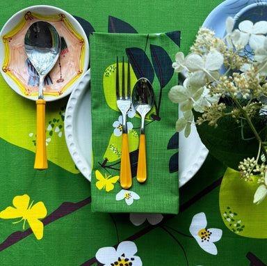 Beautifully arranged Pear Napkin Set on a dining table, showcasing four 100% cotton napkins with vibrant pear graphics.