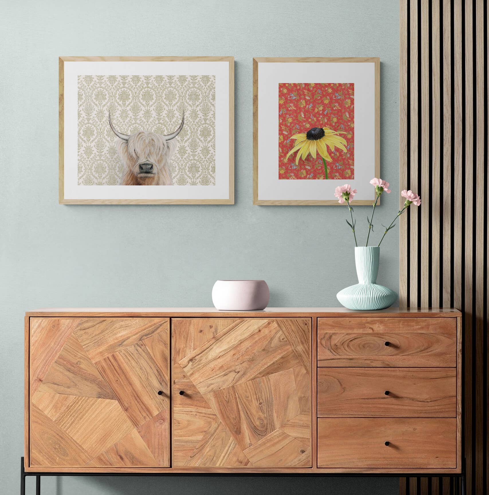 Modern room with two framed art prints hanging above a wooden sideboard.