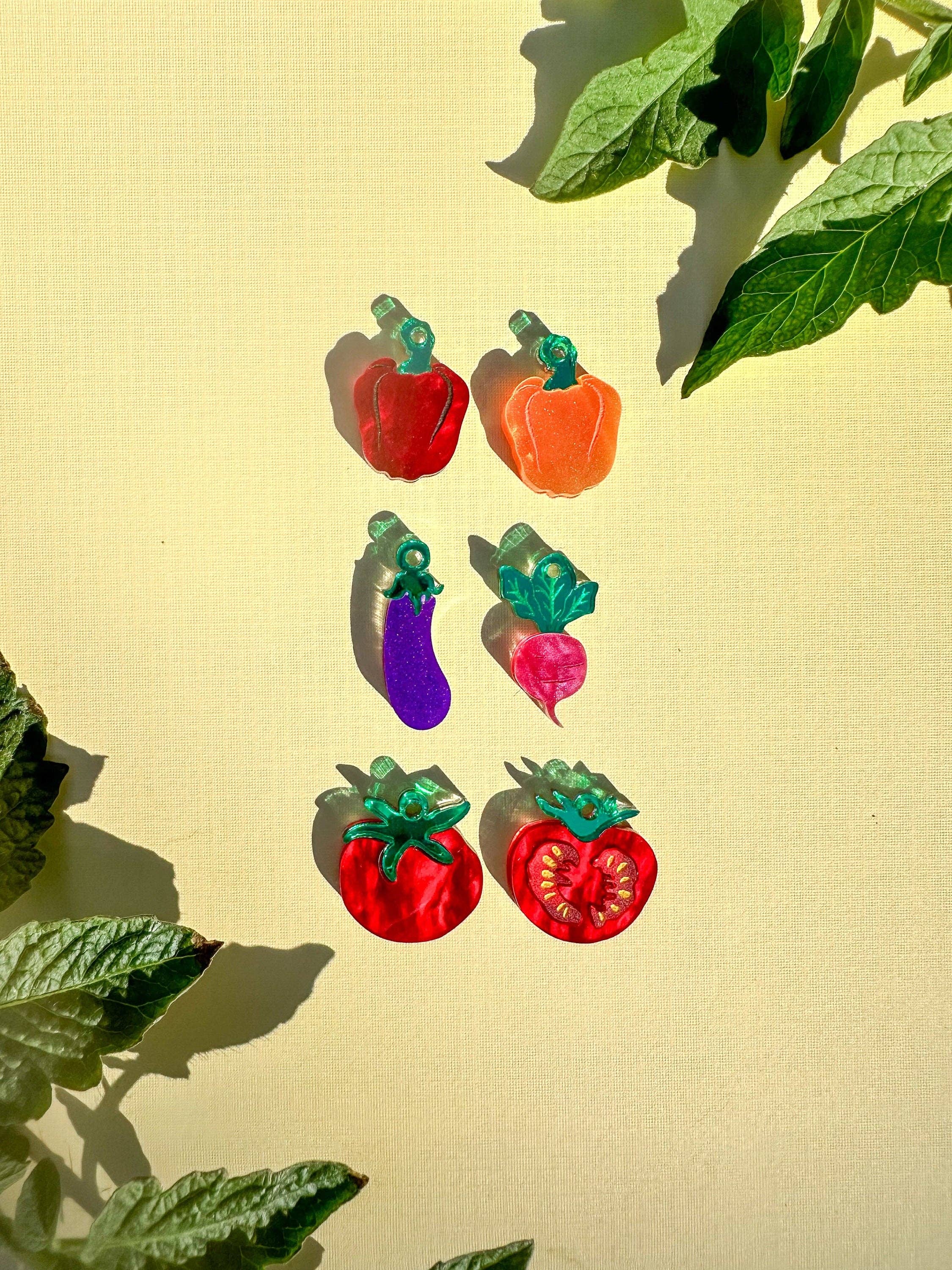 Collection of colorful acrylic vegetable earrings including Mini Radish Dangle by Sunnie Creative, showcasing various playful designs like peppers and eggplants, ideal for casual wear.