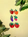 Collection of colorful acrylic vegetable earrings including Mini Radish Dangle by Sunnie Creative, showcasing various playful designs like peppers and eggplants, ideal for casual wear.