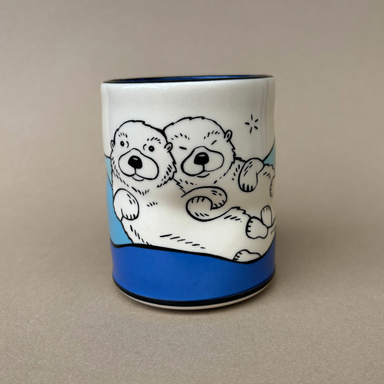 Lucky Otter Cup featuring a playful illustration of two otters cuddling, designed by The Bowl Maker.